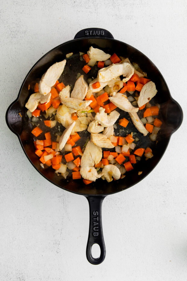 Chicken and carrots in a skillet. 