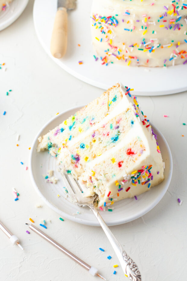 Funfetti Cake sliced on a plate with a fork. 