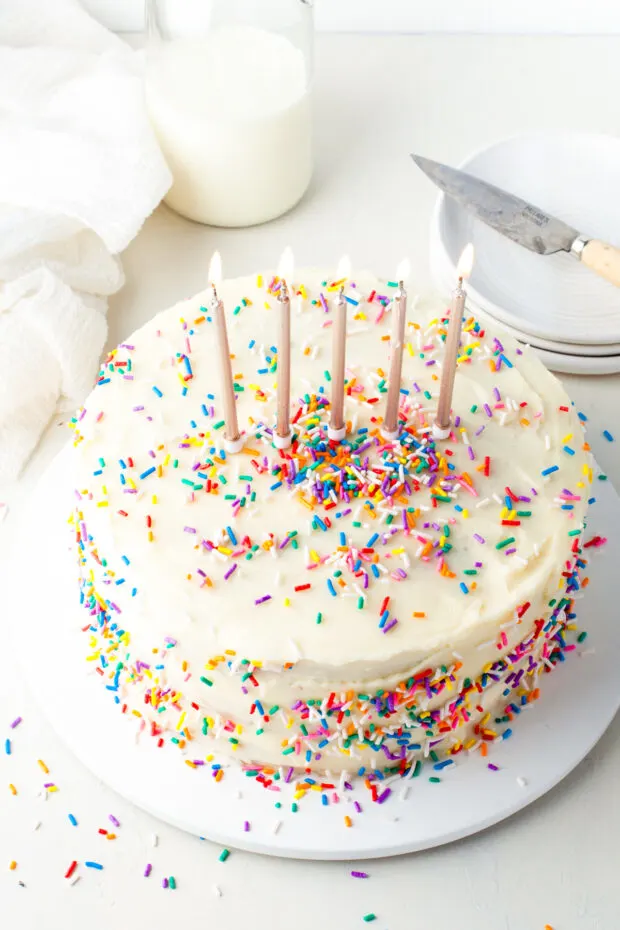 Confetti cake topped with sprinkles and birthday candles. 