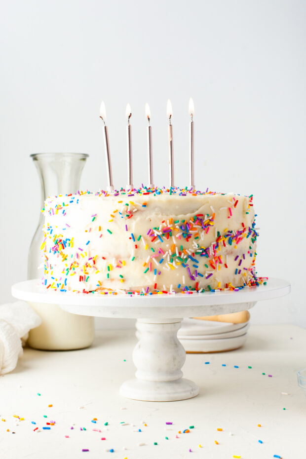 Funfetti Cake on a cake stand with candles. 