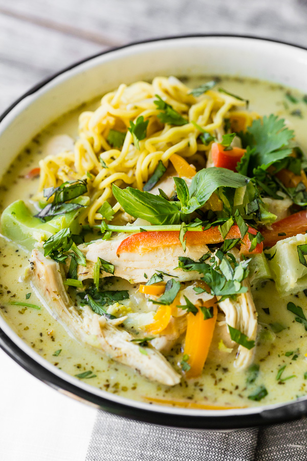 Green Curry Chicken Noodle Soup in a bowl topped with Thai basil. 