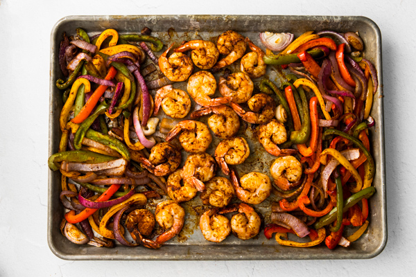 Shrimp and bell peppers cooked on a sheet pan for fajitas. 