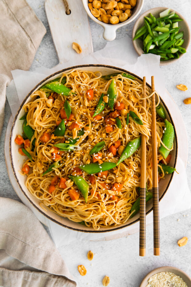 Spicy Peanut Noodles served with a chop stick and green onions. 