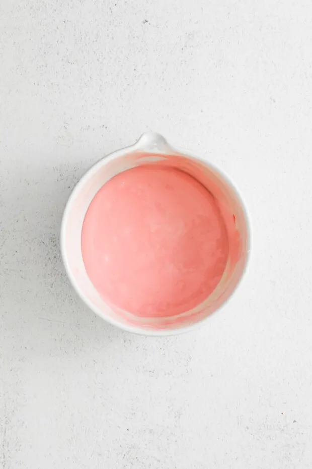 A bowl of pink icing. 