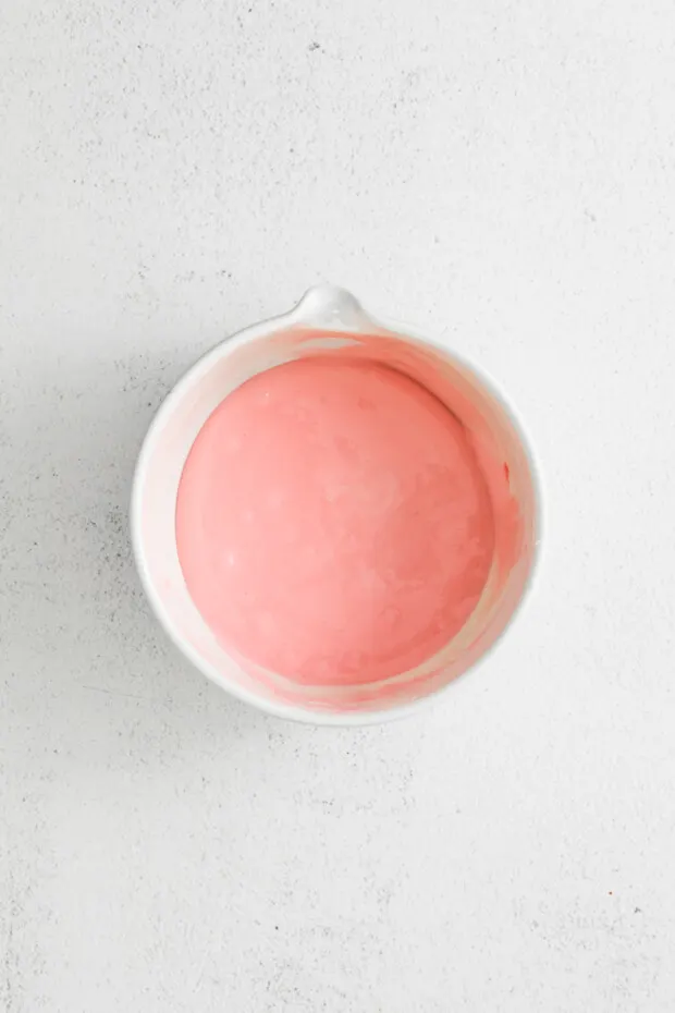 A bowl of pink icing.