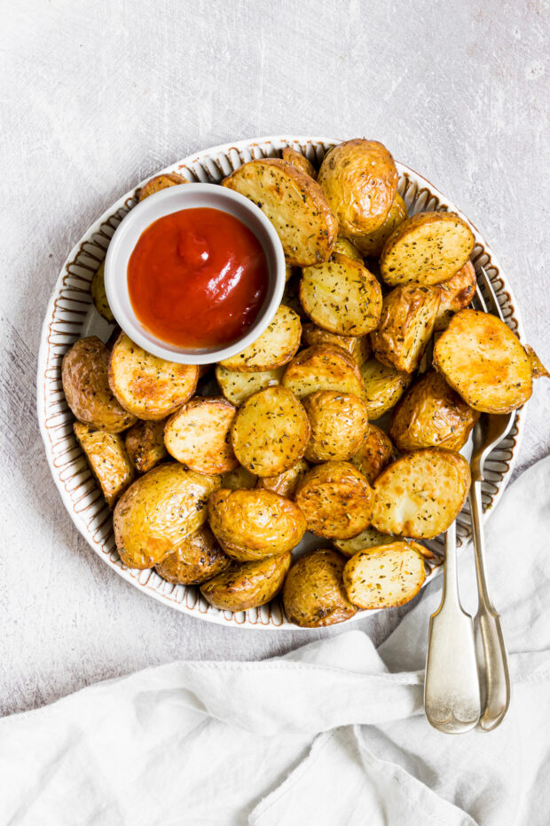 Air Fryer Roasted Potatoes on a plate with ketchup. 