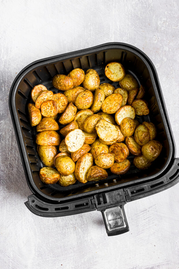 Air Fryer Roasted Potatoes sitting in an air fryer basket. 