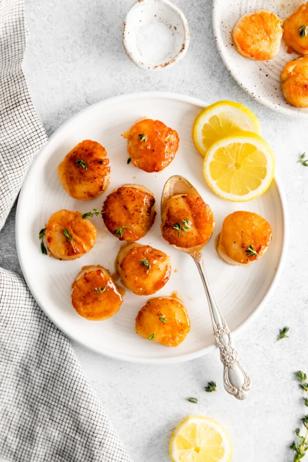 Seared Scallops on a plate with lemon.