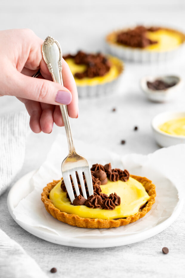 A fork going in for a bite of Boston Cream Pie Tarts. 