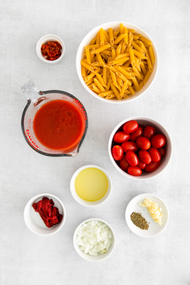 Ingredients to make Penne Arrabbiata sitting on a table. 