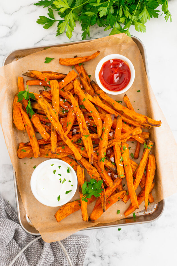 Sweet Potato Fries on a sheet pan with parchment paper. 