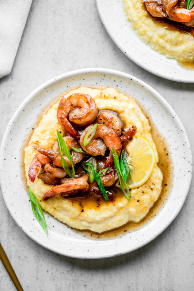 Cajun Honey Butter Shrimp and Grits on a white serving plate. 