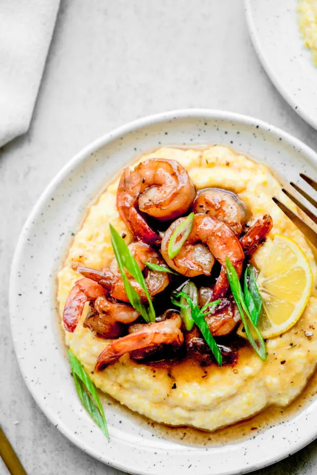 Cajun Honey Butter Shrimp and Grits topped with green onions. 