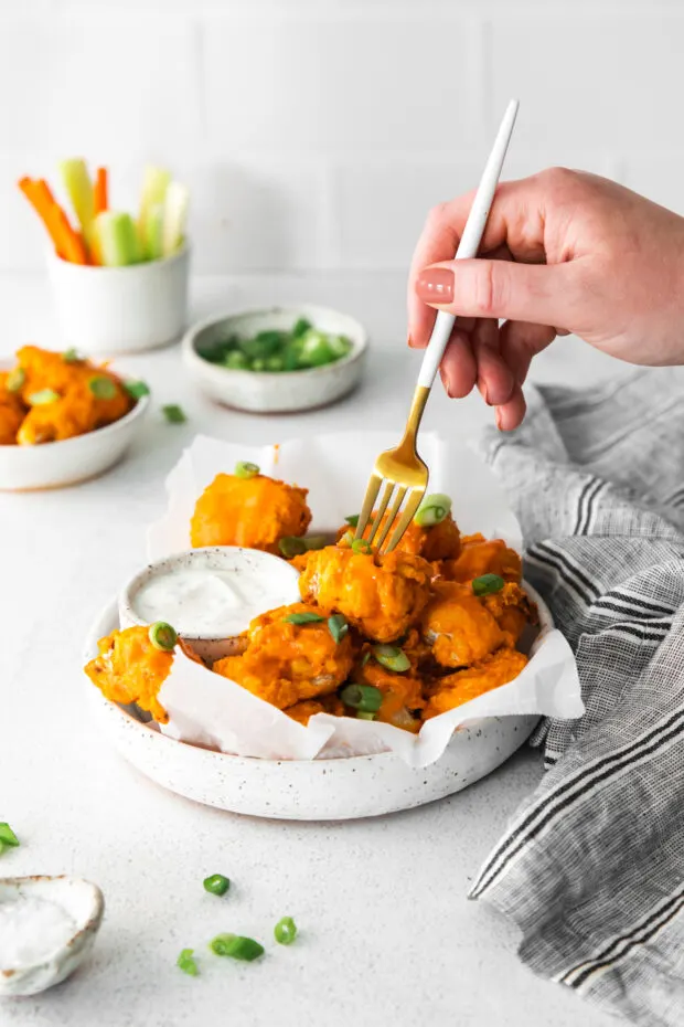 Air Fryer Buffalo Chicken Nuggets in a bowl with a fork taking a bite. 