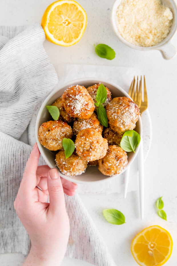 A bowl of Air Fryer Chicken Meatballs served with parmesan cheese. 