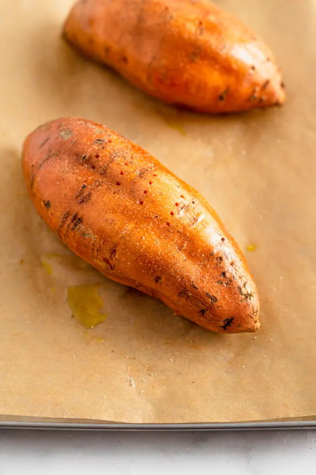 A raw sweet potatoes on parchment paper. 