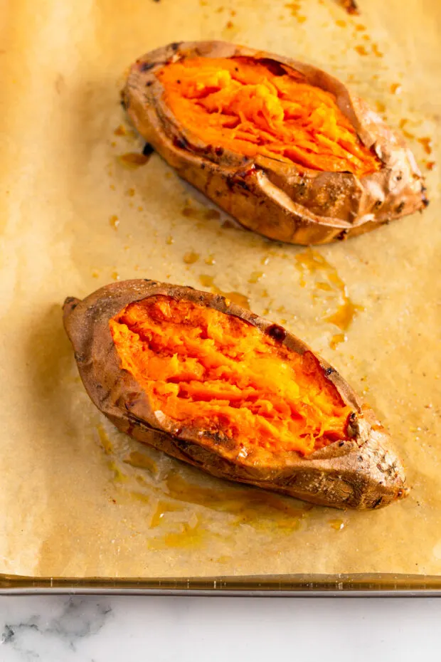 A cut open cooked sweet potato on parchment paper. 