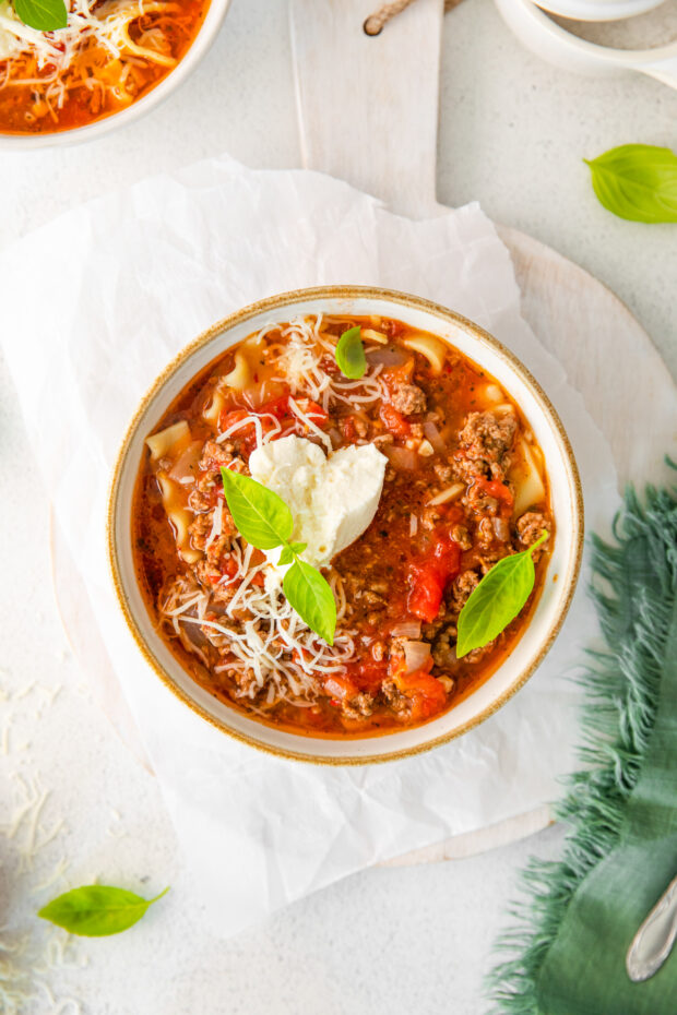 lasagna soup topped with ricotta cheese. 