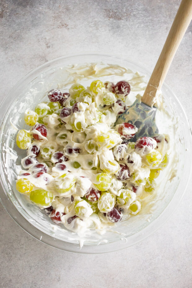 Grapes mixed with marshmallow fluff and cream cheese in a bowl. 