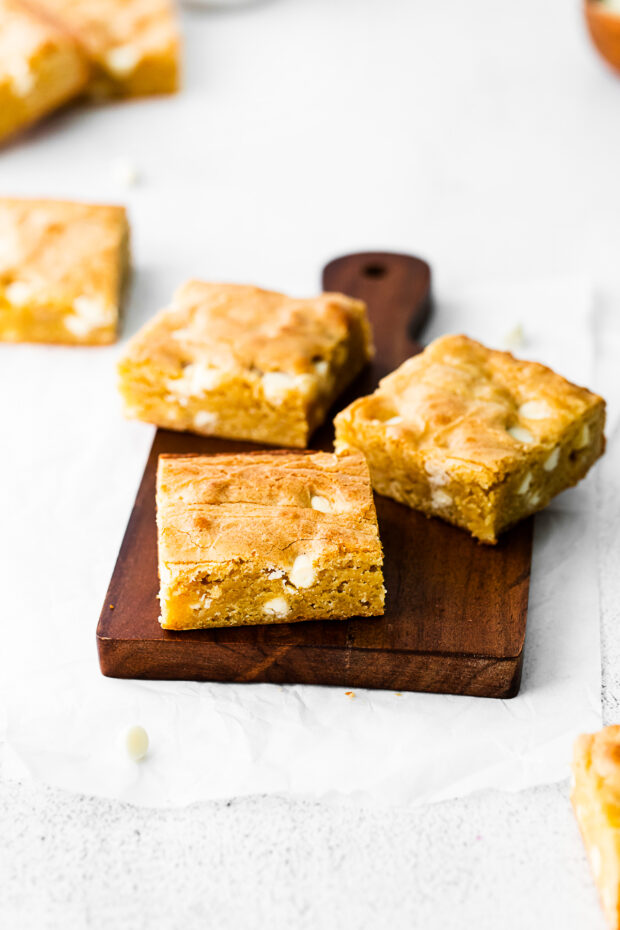White Chocolate Chip Blondies on a cutting board. 