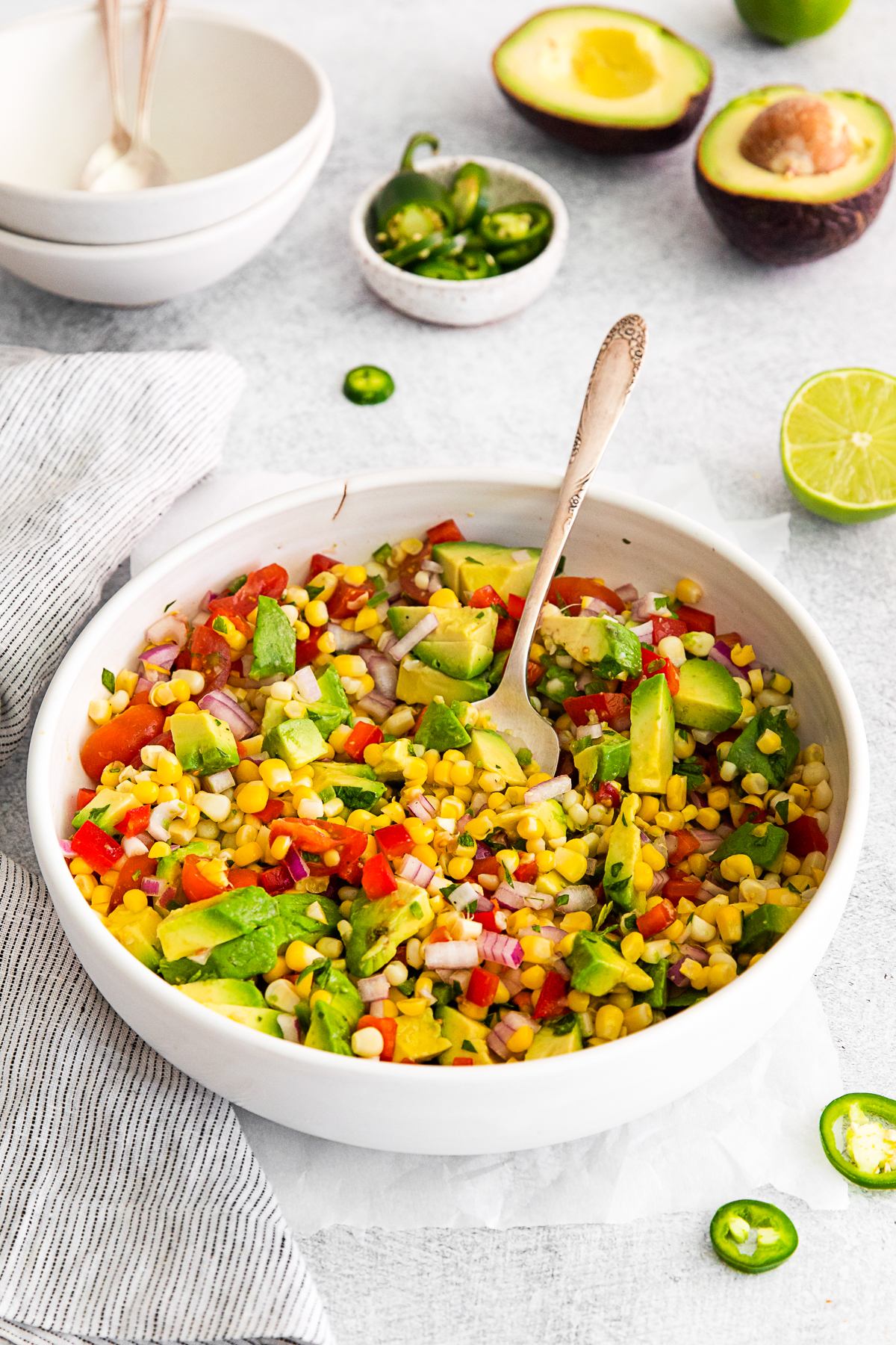 Avocado Corn Salad with a spoon in the bowl. 