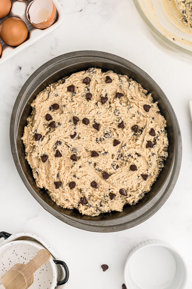 Uncooked Chocolate Chip Cookie Cake in a pan. 