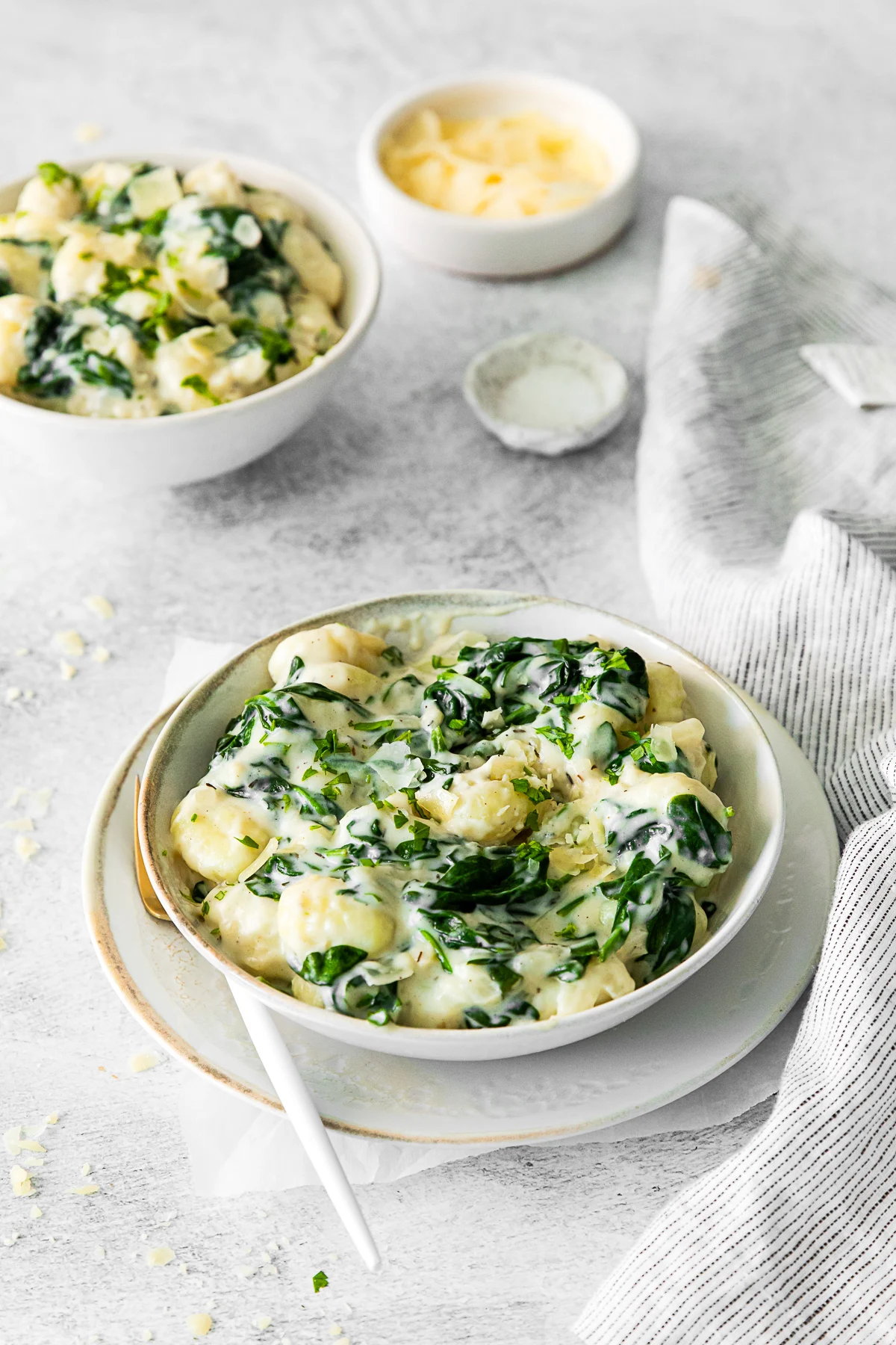 Creamy Spinach Gnocchi garnished with parmesan. 