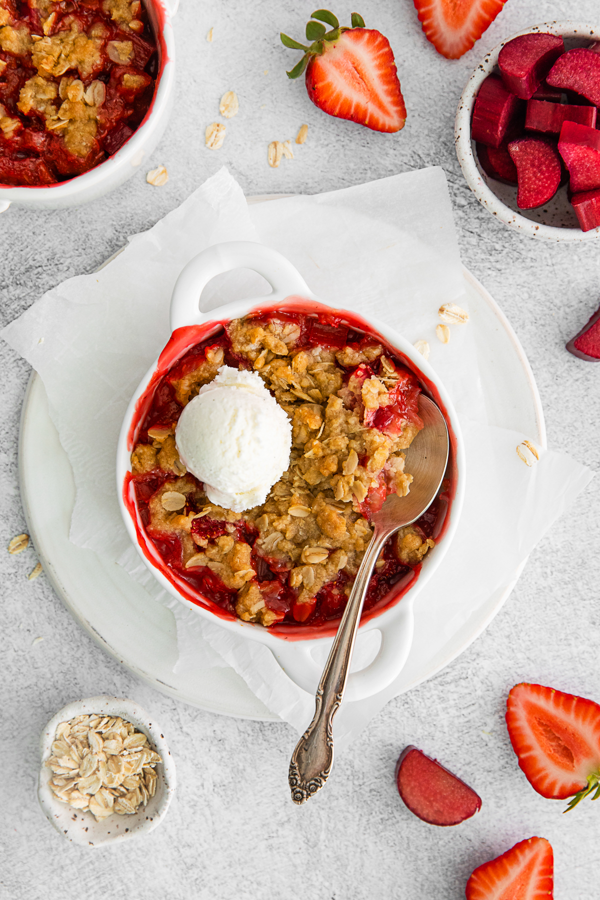 Strawberry Rhubarb Crisp in a dish topped with ice cream. 
