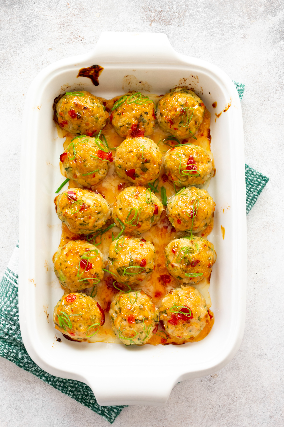 Easy Thai Baked Chicken Meatballs in a white casserole dish. 