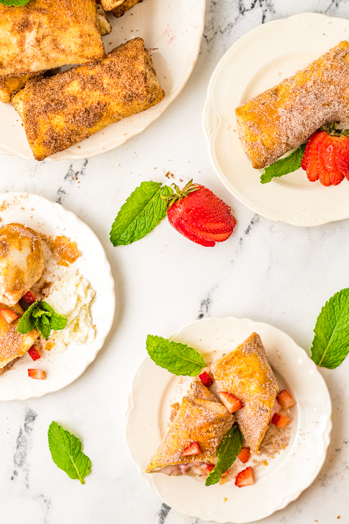 Air Fryer Strawberry Cheesecake Chimichangas served on white plates. 