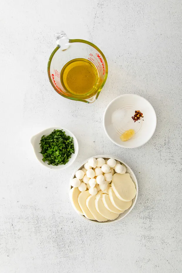 Ingredients to make Marinated Mozzarella on a table. 
