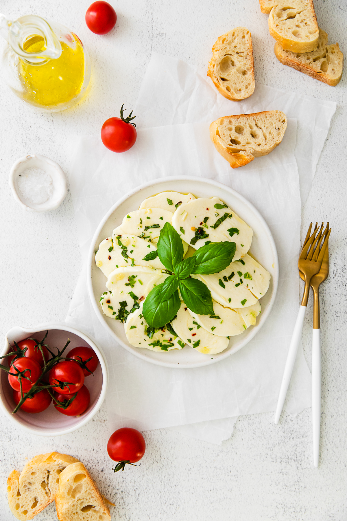 Marinated Mozzarella on a plate with forks and bread. 