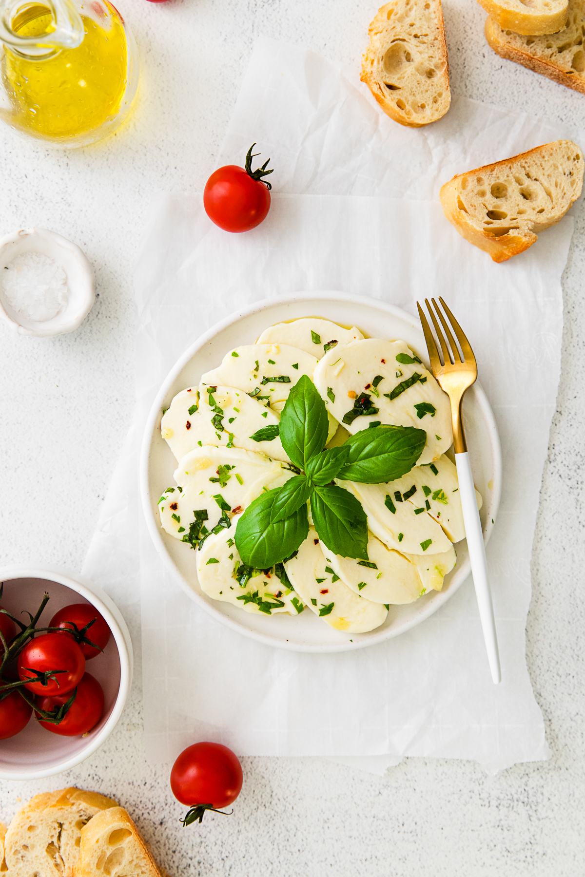 Marinated Mozzarella on a small white plate with a fork. 