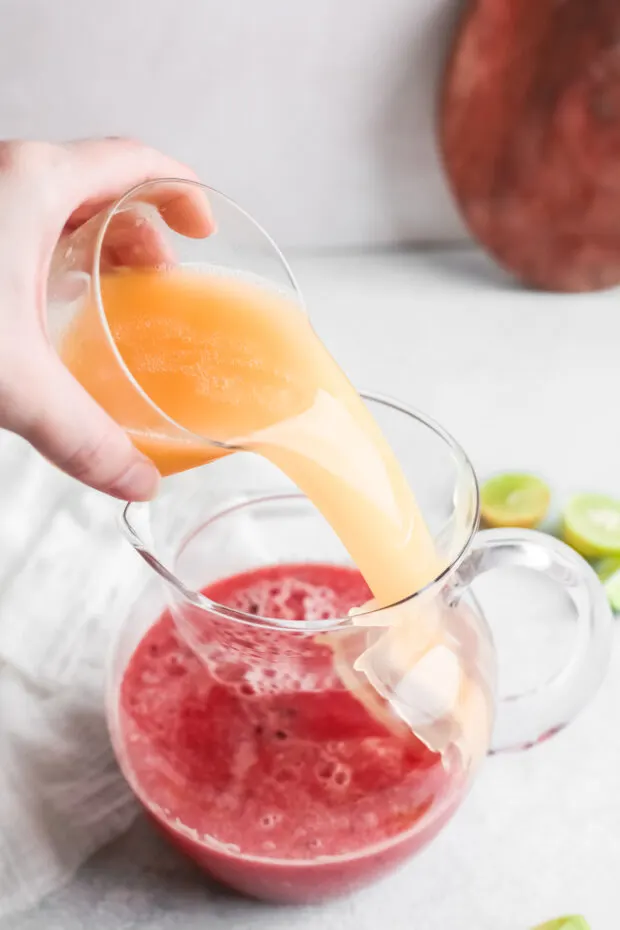 Pouring grapefruit juice into blended watermelon. 