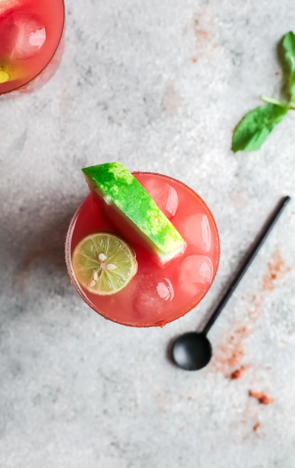 Watermelon Paloma in a glass garnished watermelon and lime. 