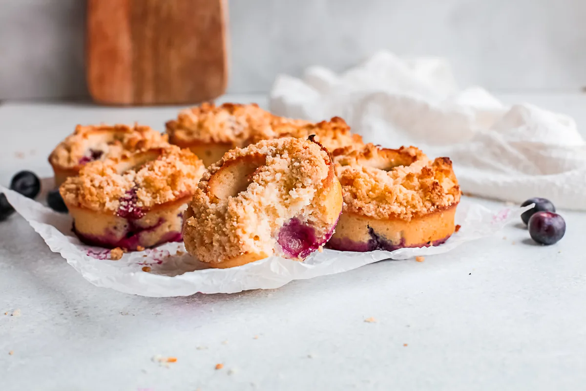Baked Blueberry Streusel Donuts sitting on a piece of parchment paper. 
