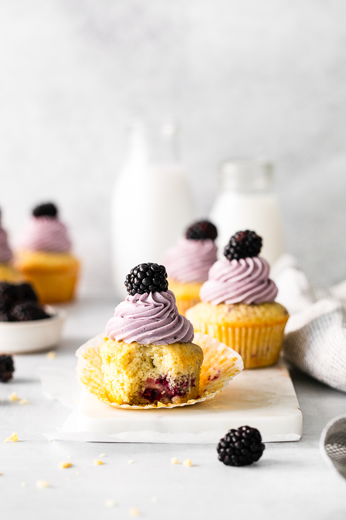A Blackberry Cupcake with a bite taken out of it. 