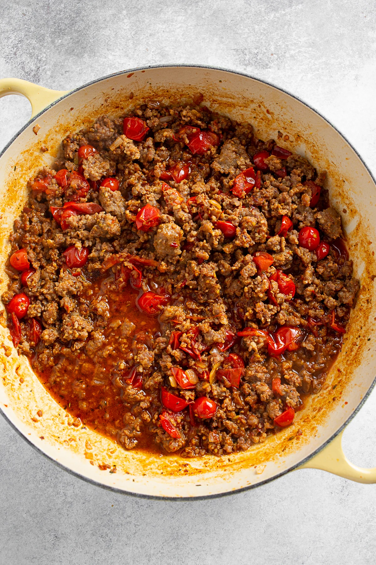 Italian sausage and tomatoes in a skillet. 