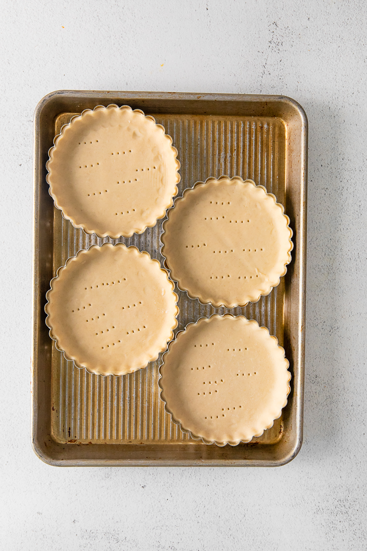 Pie crust in a mini tart pans ready to be baked. 