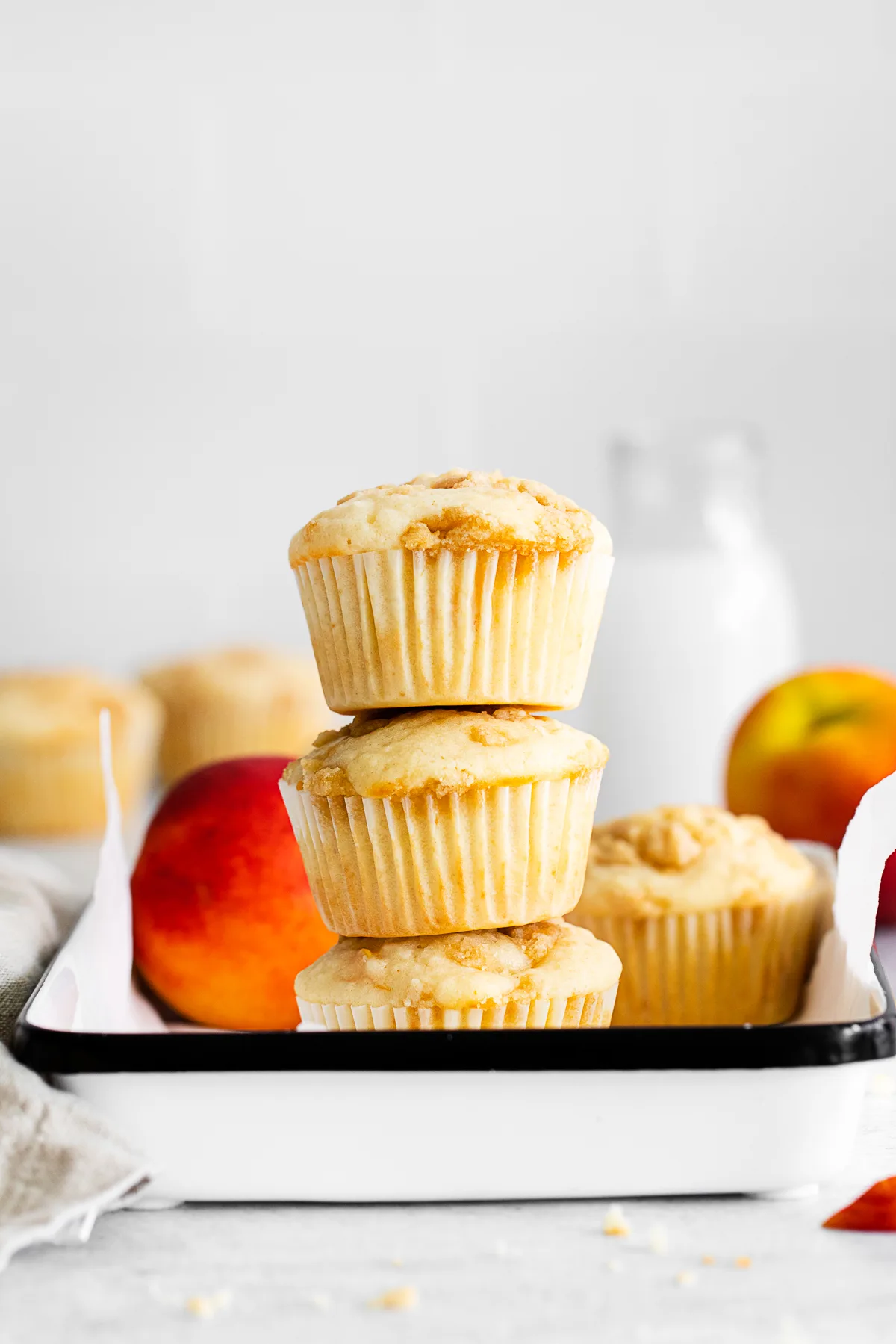 Peach Streusel Muffins stacked on top of each other. 