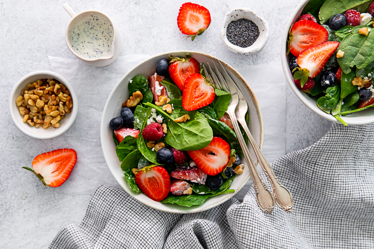 Spinach Berry Salad in a bowl with fork in the bowl. 