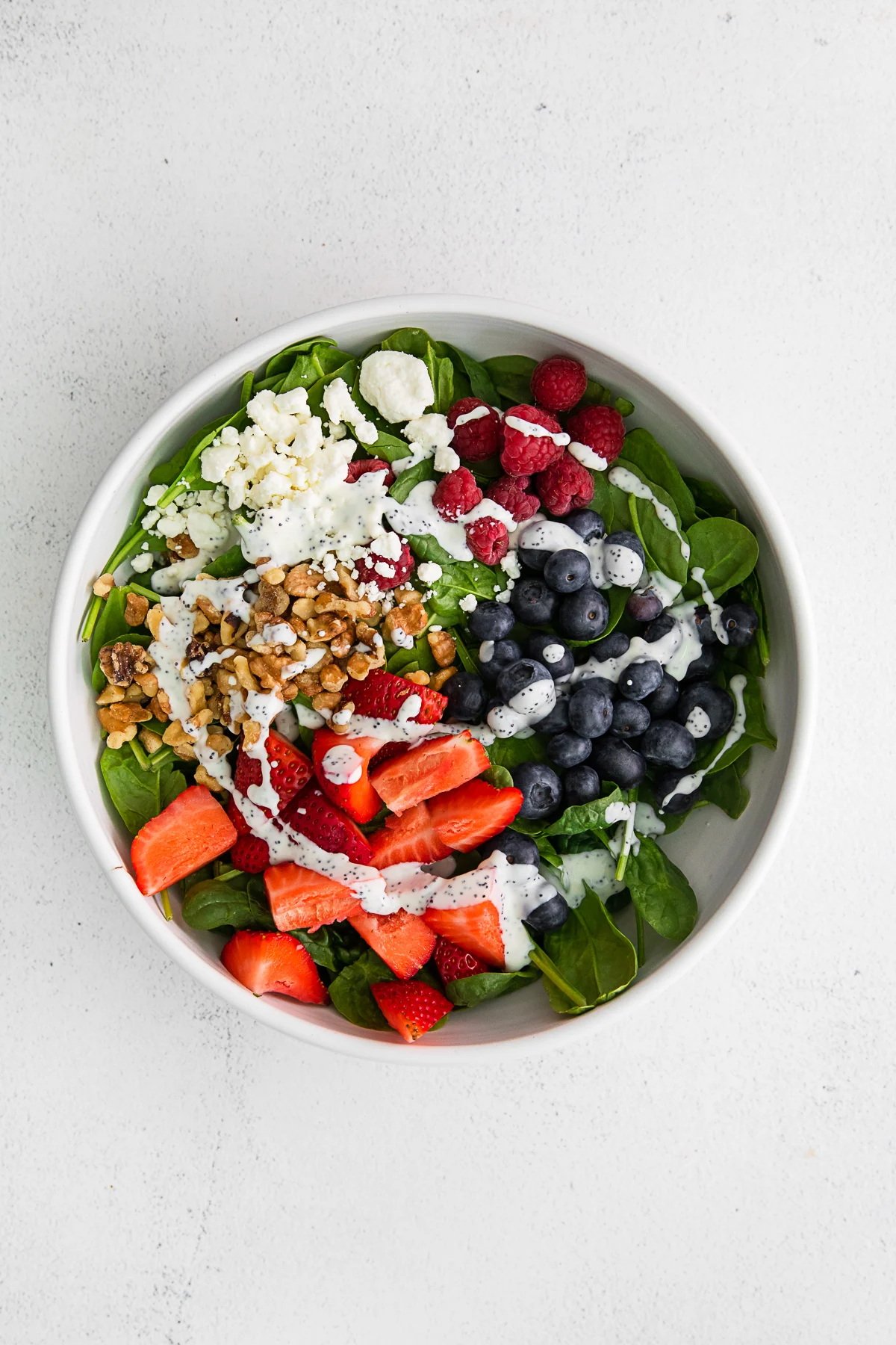 Spinach Berry Salad drizzled with homemade poppy seed dressing.