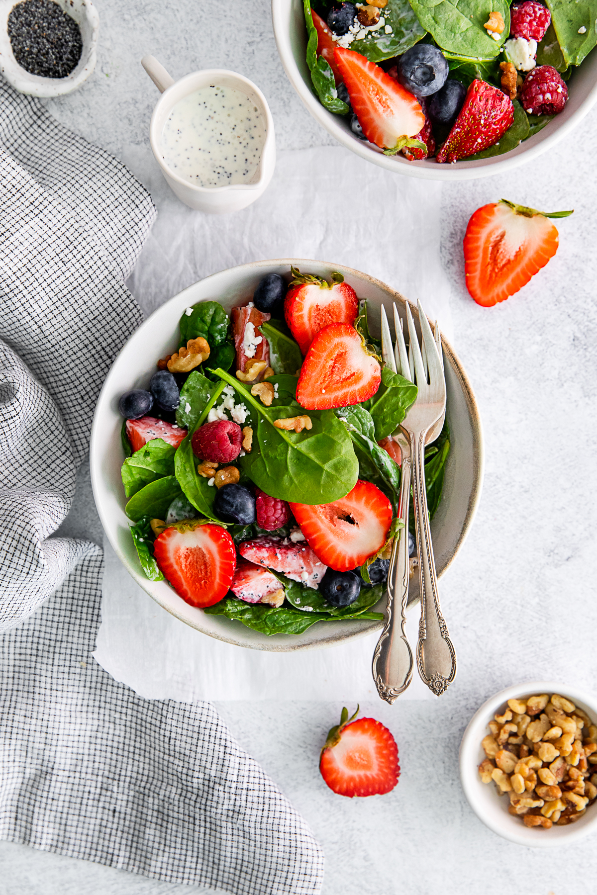 Spinach Berry Salad in a bowl with extra berries on top. 