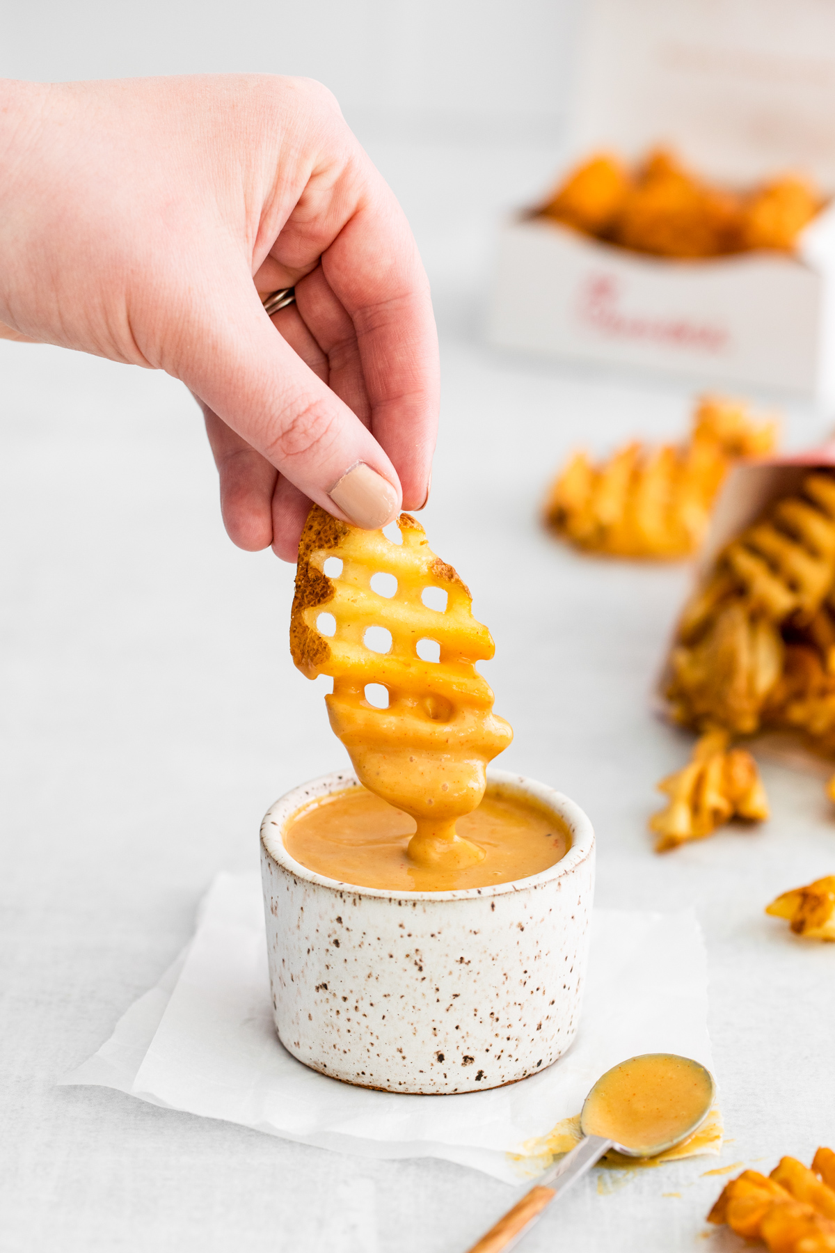 A fry being dipped into Copycat Chick-fil-A Sauce.