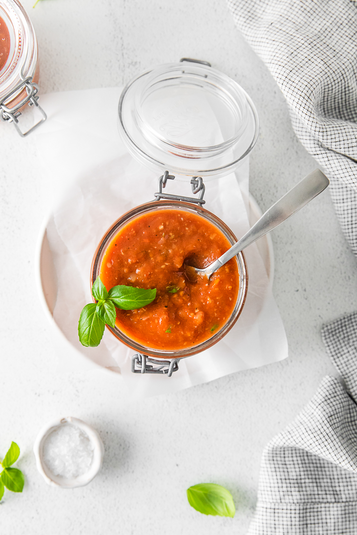 Roasted Tomato Sauce in a jar with a spoon. 