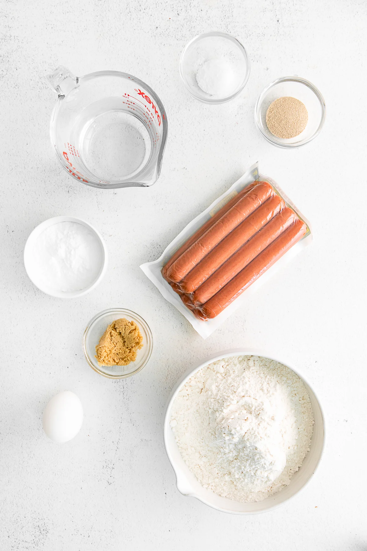 Ingredients to make homemade pretzel dogs on a table. 