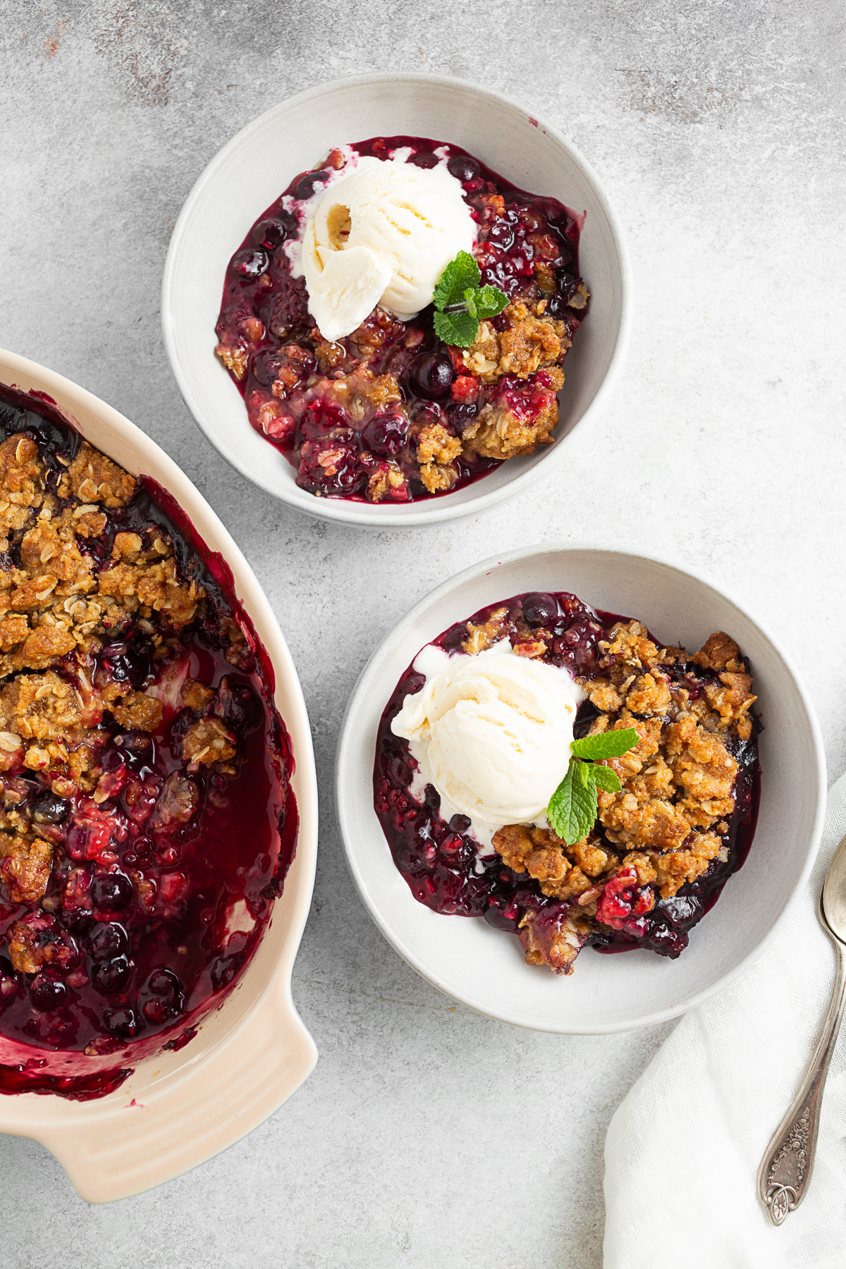Berry crisp scooped into 2 bowls. 