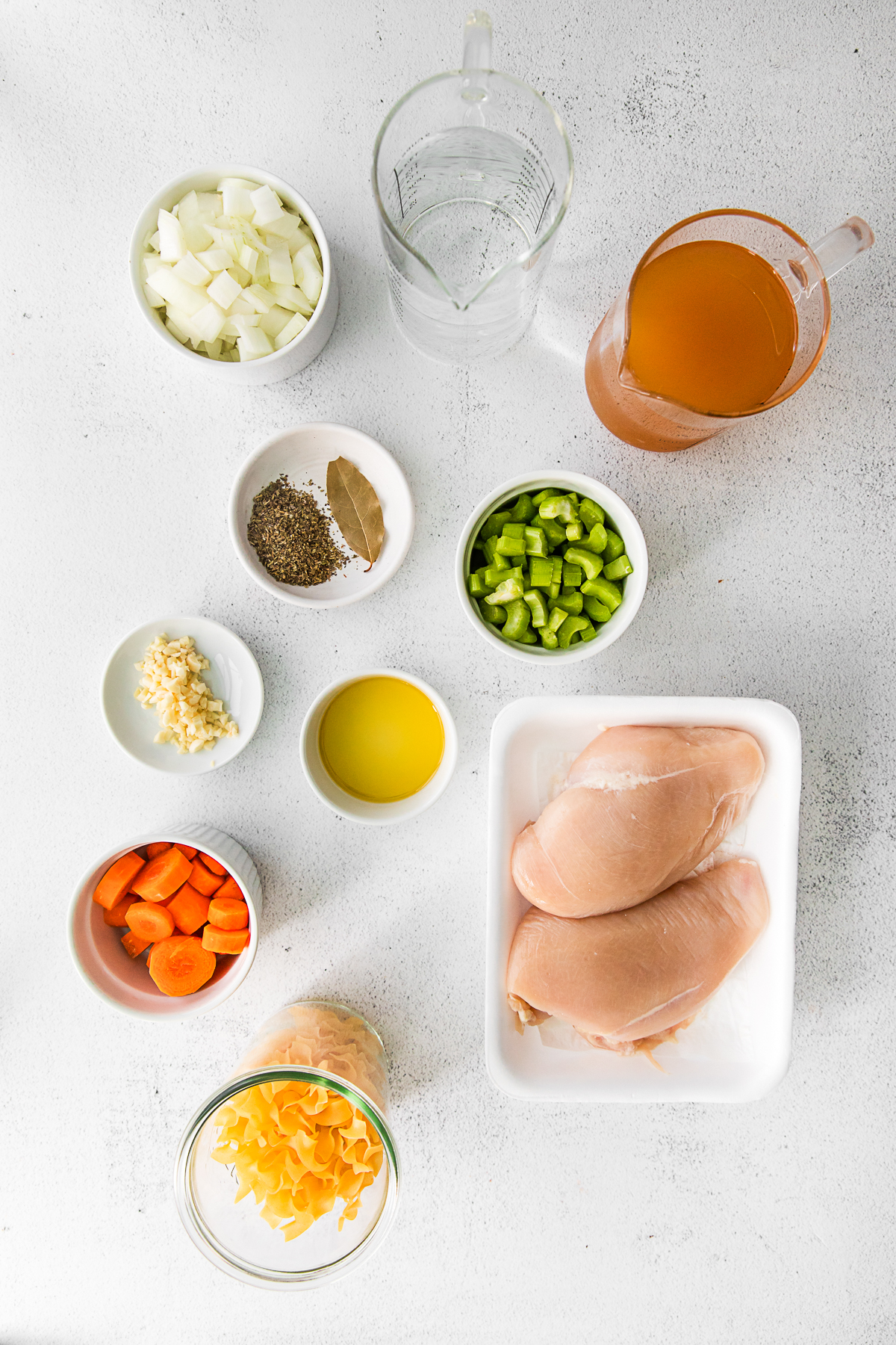 Ingredients to make Instant Pot Chicken Noodle Soup on a table. 