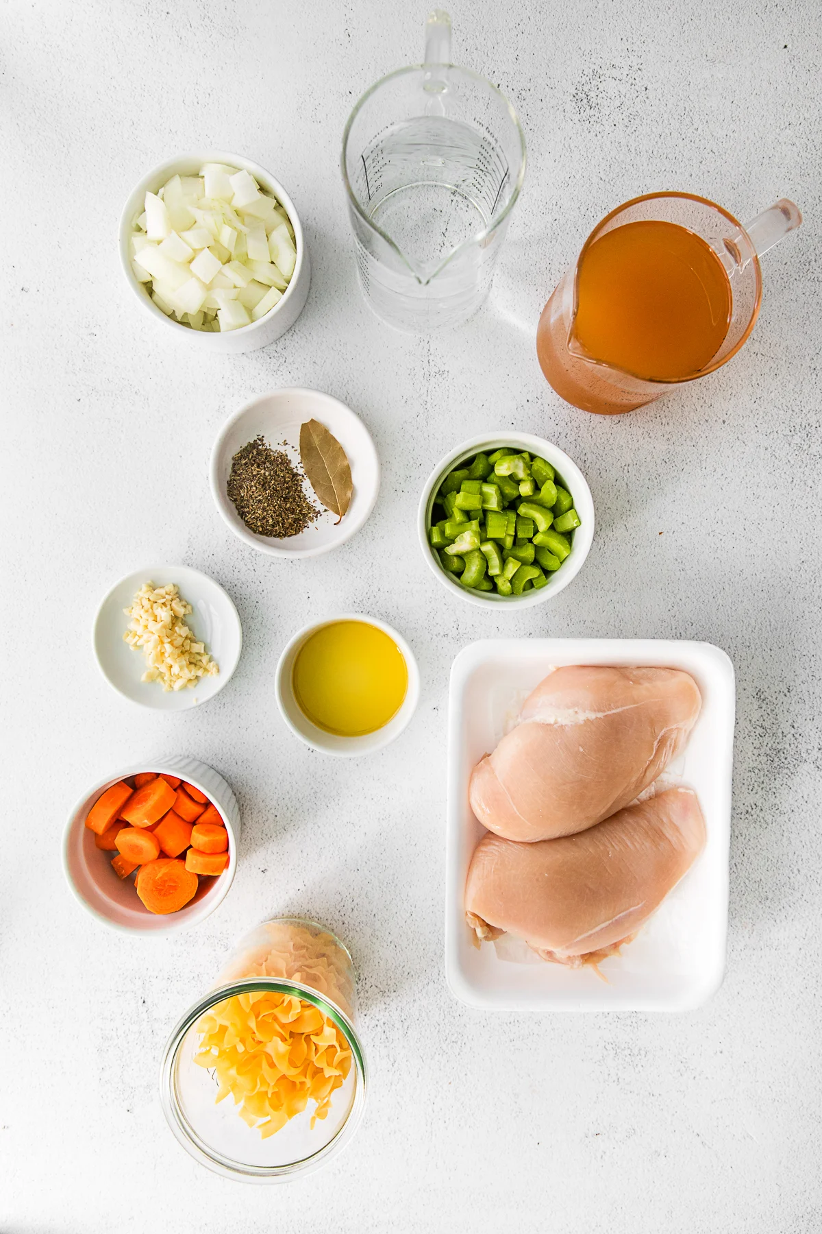 Ingredients to make Instant Pot Chicken Noodle Soup on a table. 