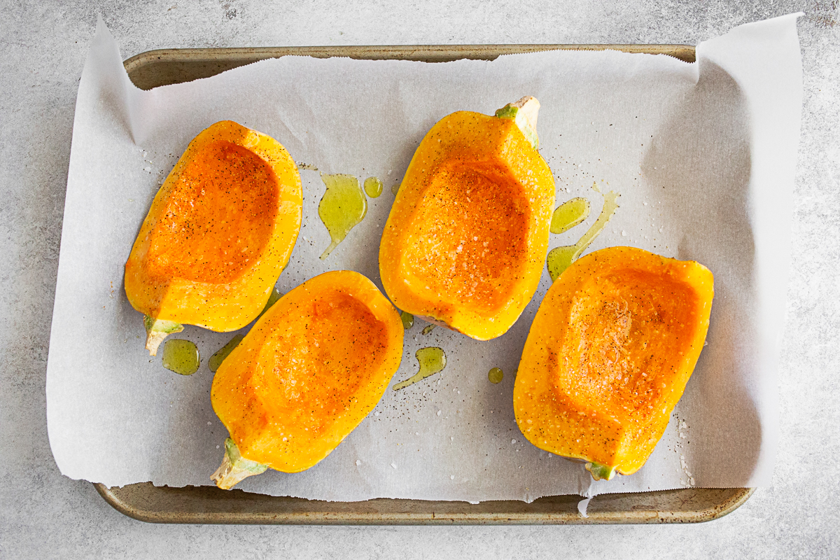Uncooked koginut squash on a sheet pan with parchment paper. 